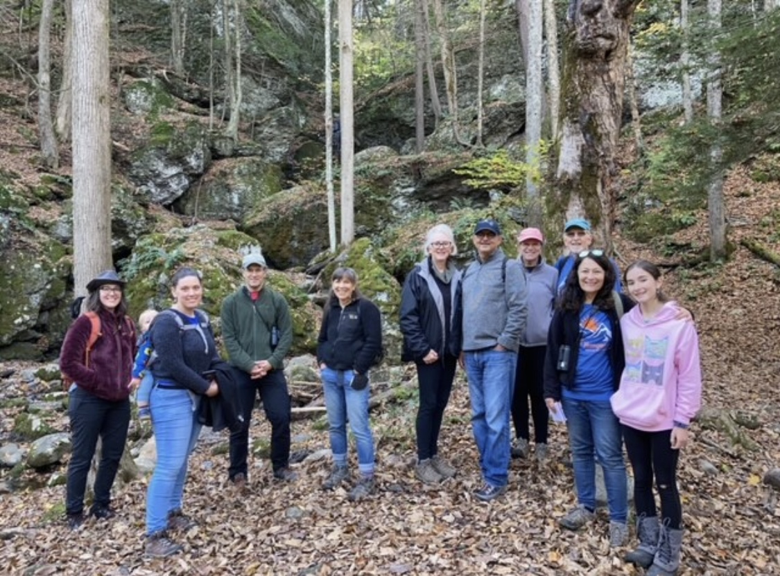 Group of Hike for Hunger participants smiling on a forest trail in Amherst, Massachusetts.