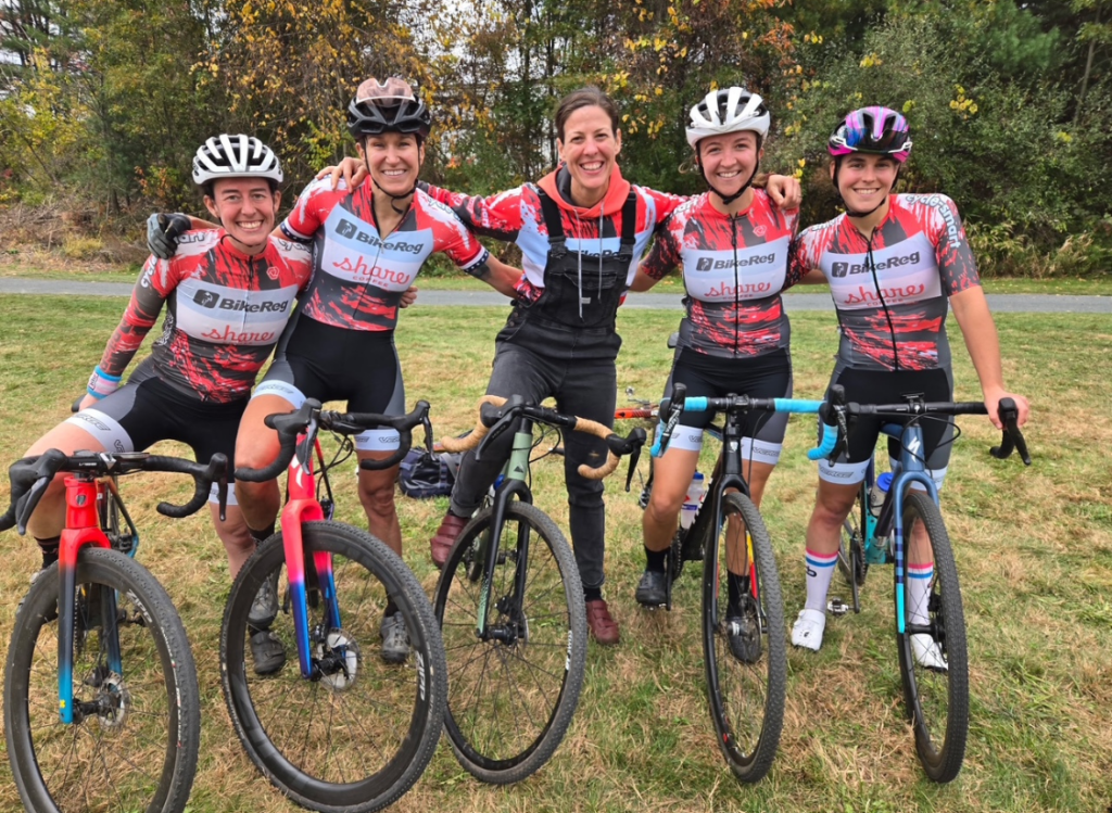 BikeReg | Share Coffee women’s cycling team standing together with their bikes after a cyclocross race, celebrating teamwork and community.